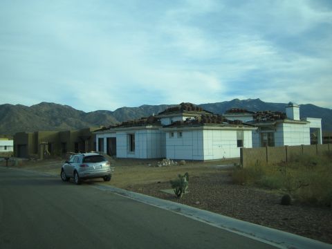 1968 Ford Mustang - A silver SUV is parked on a street in a desert landscape with mountains in the background.