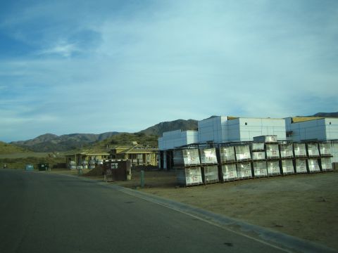 1968 Ford Mustang - A construction site is shown with unfinished buildings and stacks of materials, some labeled with the number '82'.