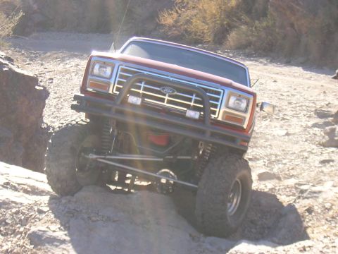 1984 Ford Bronco - A modified Ford Bronco navigates a challenging off-road path.