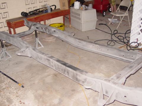 1979 Ford Bronco - Vehicle frame undergoing restoration, supported by jack stands in a workshop setting.