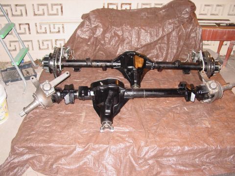 1979 Ford Bronco - Two Ford Bronco rear axles are displayed on a brown tarp, suggesting they are parts for a vehicle restoration.
