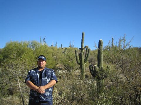1968 Ford Mustang - A man poses for a photo in a desert landscape filled with saguaro cacti and scrub brush.