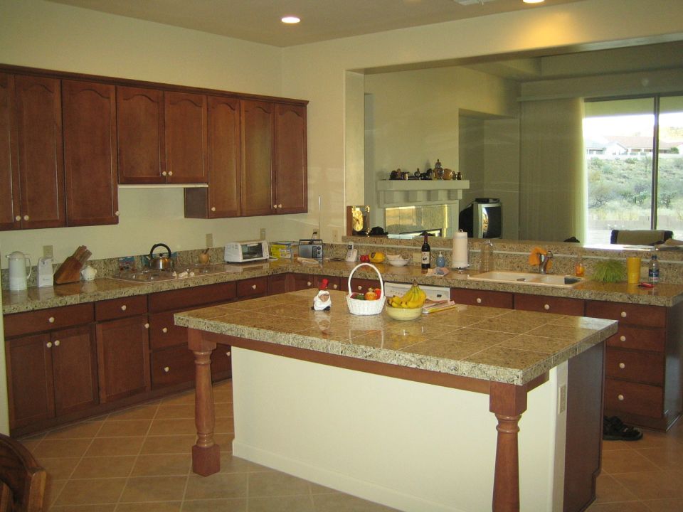 Kitchen with wood cabinets, granite countertops, and an island. A window shows an outdoor view