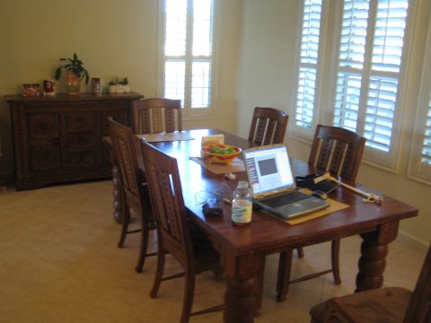 1968 Ford Mustang - A dining room scene with a wooden table set for a meal, a laptop and a sideboard.