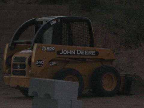 1968 Ford Mustang - A yellow John Deere skid steer loader is parked outdoors, with the model number 240 visible on its side.