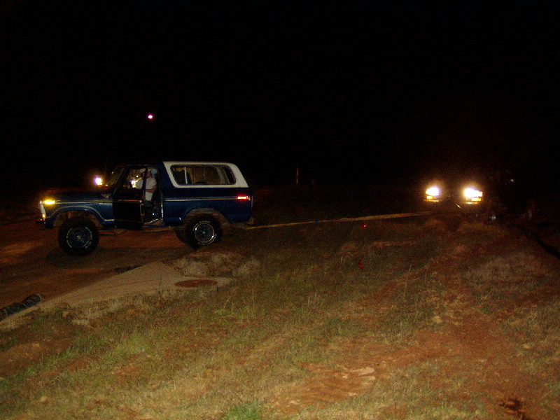 1978 Ford Bronco side view at night, open door, another vehicle approaching