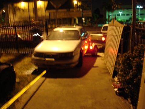 1992 Ford Taurus - A white 1992 Ford Taurus sedan is seen from the front, towing a trailer at night.