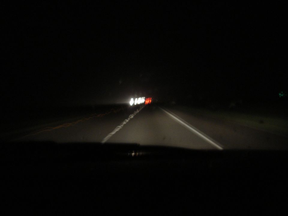 driving on highway at night, headlights and taillights visible