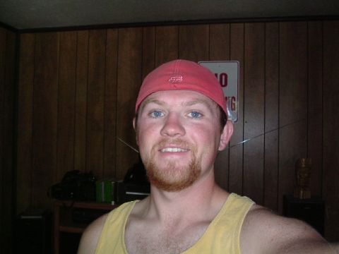 1979 Ford Bronco - A man wearing a red Fox hat and a yellow tank top poses for a photo indoors.