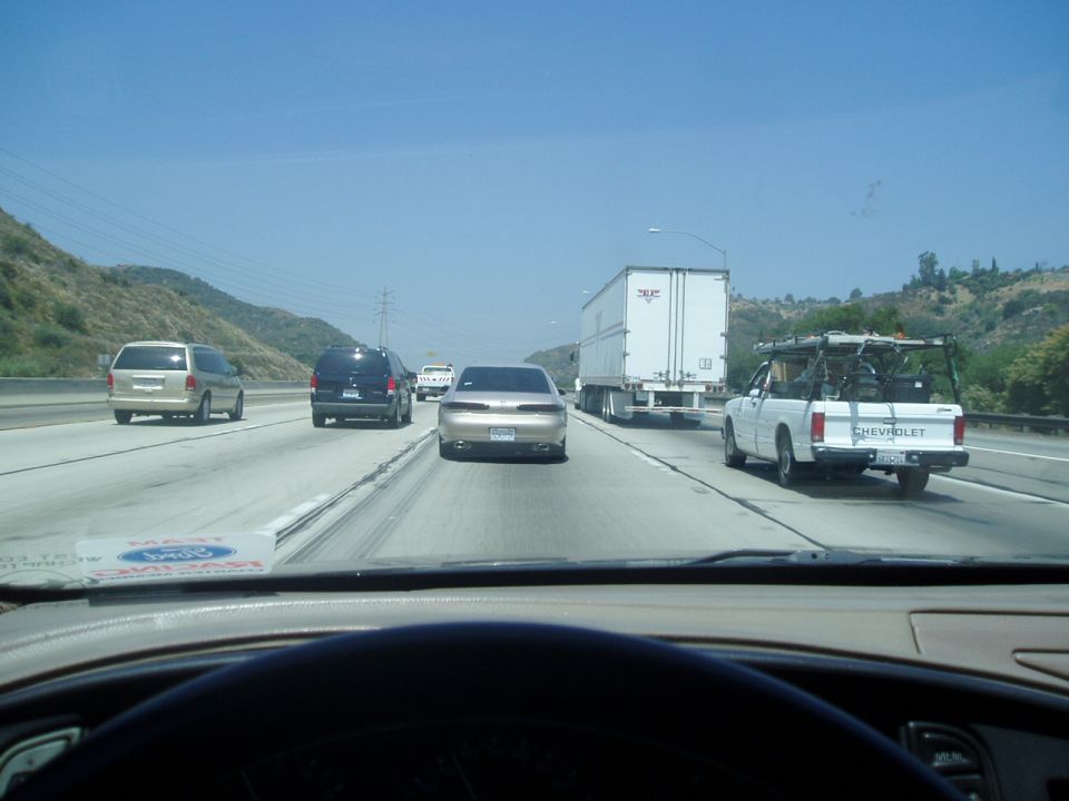 1998 Mercury Sable driving on highway behind a white Chevrolet pickup truck
