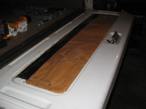 1995 Ford Bronco - A white tailgate with a brown fabric insert and chrome handle is shown.