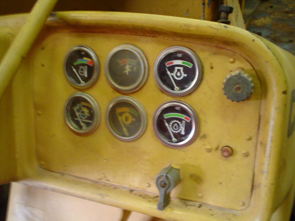Yellow dashboard with six gauges and a control lever