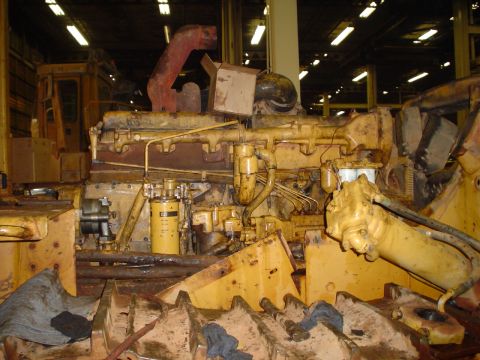 1966 International School Bus - Close-up view of a large yellow engine with various hoses and filters, likely in a repair shop.
