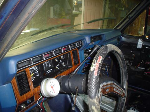 1984 Ford Bronco - Interior view of a vehicle's dashboard and steering wheel, showing an aftermarket gauge.