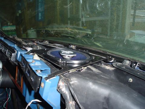 1984 Ford Bronco - A speaker is being installed in the dashboard of a vehicle, with wiring exposed.