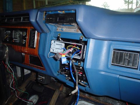 1984 Ford Bronco - The dashboard of a vehicle shows exposed wiring and an empty stereo slot, indicating an ongoing repair or upgrade.