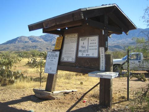 1968 Ford Mustang - A wooden kiosk displays various public access and trail project information, with a white pickup truck visible in the background under a cl…