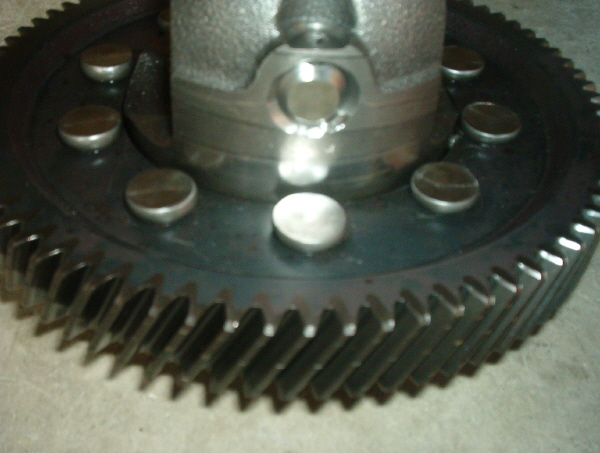 Close-up of a large gear with several bolts around its center