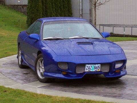 1993 Ford Probe - A blue 1993 Ford Probe is shown from a three-quarter front view on a rainy day.