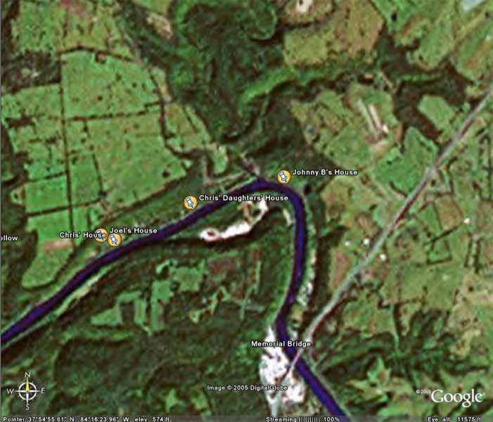 Aerial view of a river with labeled houses and Memorial Bridge, with a road and fields nearby