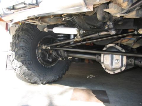 1995 Ford Bronco - This image shows the undercarriage of a vehicle, focusing on the suspension and differential, with large off-road tires visible.