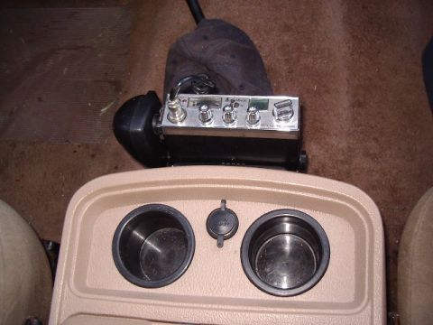 1985 Ford Bronco - Interior view of a car's center console showing a CB radio and cup holders.