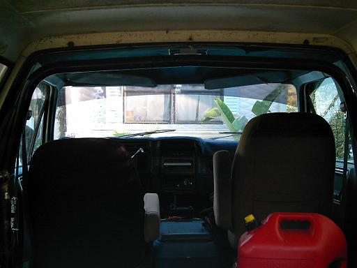 Interior shot from cargo area past two bucket seats to the dash, red fuel jug on the floor