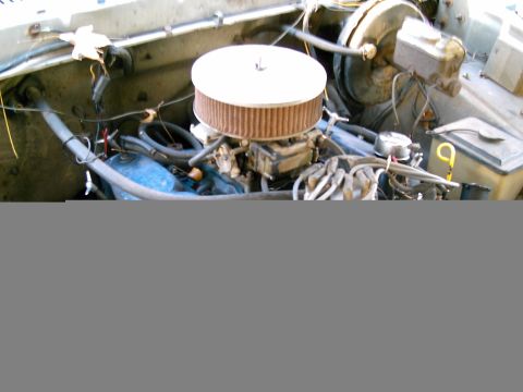 1986 Ford Bronco - Close-up view of an engine bay, showing the carburetor and air filter assembly.