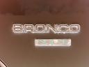 1986 Ford Bronco - Close-up of a Bronco nameplate on a vehicle part.