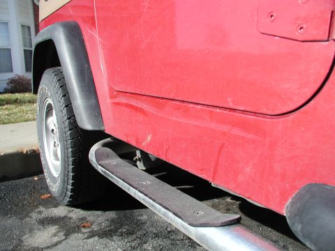 1998 Jeep TJ - Side view of a red Jeep showing its door and fender.