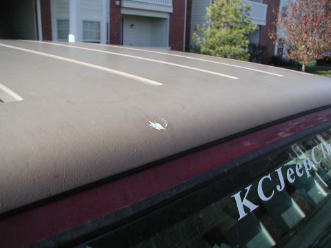 1998 Jeep TJ - Close-up of a Jeep's hardtop, showing some wear and a club sticker on the rear window.