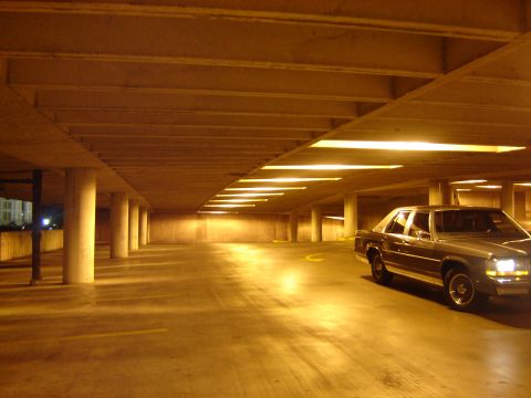 1988 Ford Crown Victoria LTD - A silver sedan is parked in an empty, dimly lit parking garage at night.