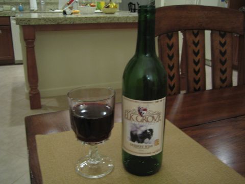 1968 Ford Mustang - A bottle of Elk Grove Sangert Wine sits next to a glass of red wine on a table.