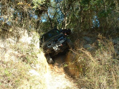 1995 Ford Bronco - Off-road vehicle navigating a challenging terrain, tilted in a steep ditch.
