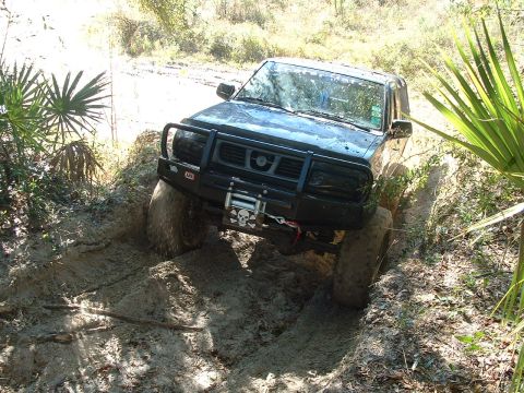 1995 Ford Bronco - This Nissan Frontier is navigating a muddy trail with large tires and a reinforced bumper.