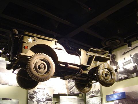 1994 Ford Bronco - Museum exhibit features a suspended military jeep with historical displays in the background.