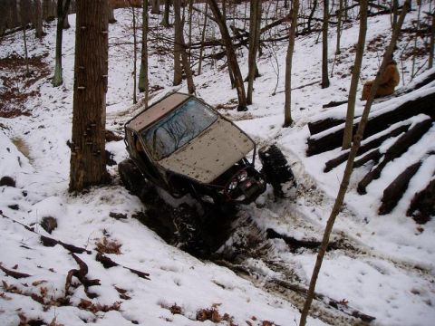 1992 Ford Bronco - This 1992 Ford Bronco is navigating a challenging snowy terrain, with one wheel lifted.
