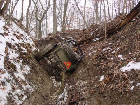 1992 Ford Bronco - Off-road vehicle stuck in a muddy ditch during winter conditions.