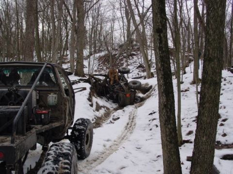 1992 Ford Bronco - Off-road vehicles navigate a snowy trail, with one vehicle overturned.