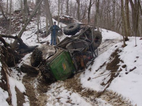 1992 Ford Bronco - Off-road buggy overturned in a snowy ditch, with a person observing the scene.