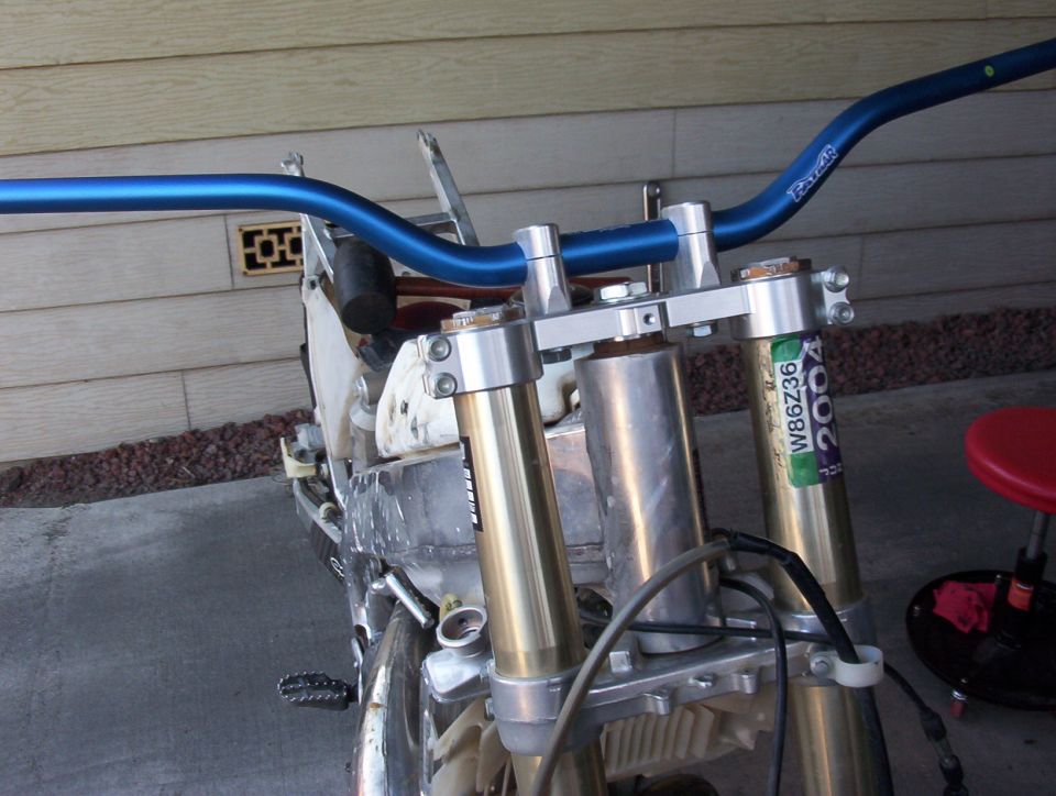 Blue handlebars and gold front suspension with a "2004" sticker