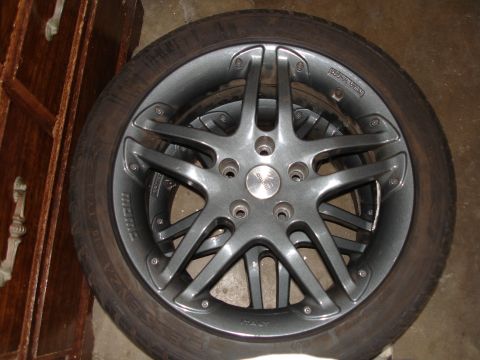 1989 Mazda MX-6 - A close-up view of a gray five-spoke alloy wheel and tire, with 'MOMO' and 'ITALY' text visible on the wheel.