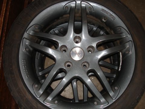 1989 Mazda MX-6 - A close-up view of a gray MOMO alloy wheel, a five-spoke design and a prominent center cap.