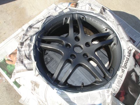 1989 Mazda MX-6 - Aftermarket wheel covered in newspaper, ready for a new coat of paint.