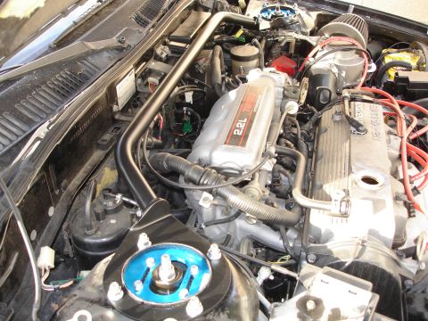 1989 Mazda MX-6 - Engine bay view of a Mazda 2.2L Turbo engine, showing the intake manifold and strut tower brace.