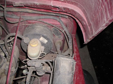 1998 Jeep TJ - Close-up view of the brake system components within a red Jeep's engine bay.