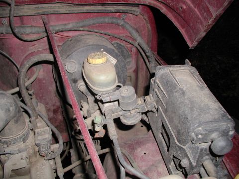 1998 Jeep TJ - Close-up view of the engine bay, focusing on the brake fluid reservoir and related plumbing.