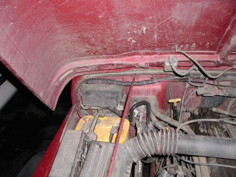 1998 Jeep TJ - Under the hood of a 1998 Jeep TJ, revealing the battery and engine components.