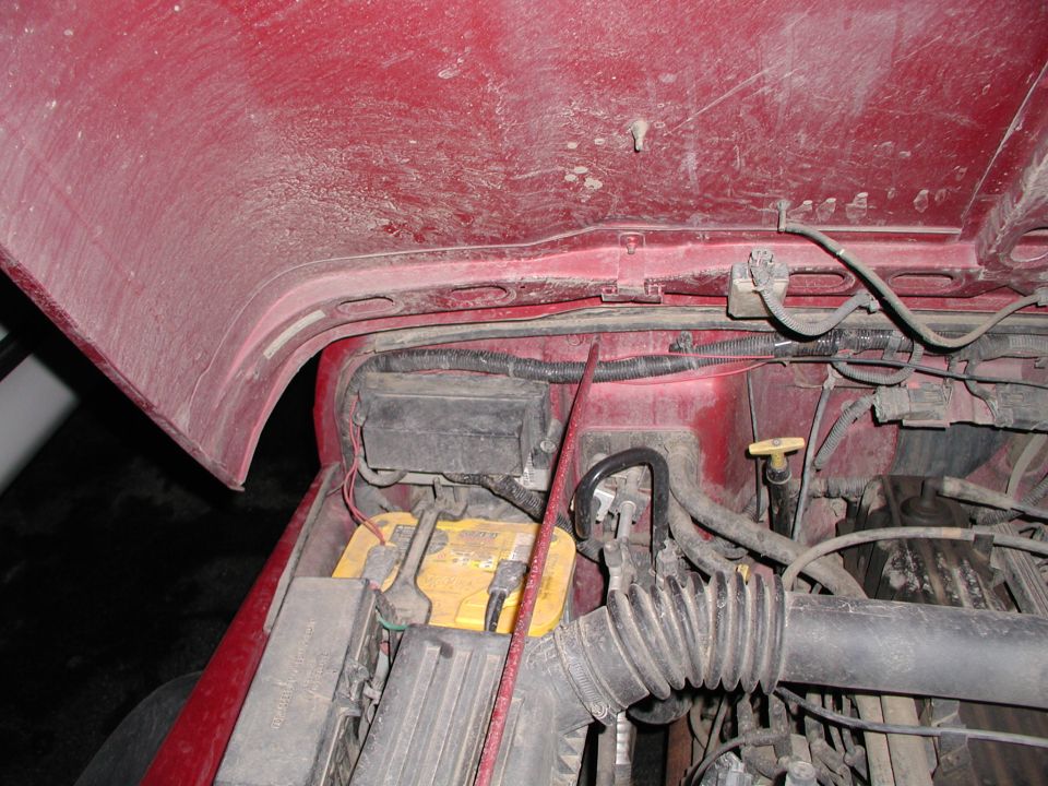 1998 Jeep TJ engine bay showing battery, fuse box, and air intake