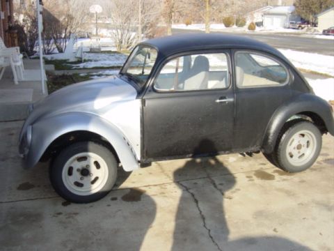 1975 Volkswagen Beetle - A Volkswagen Beetle with a silver front fender and black body sits on a driveway.